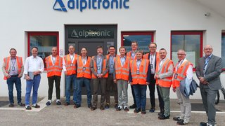 News Gruppe von Männern in Warnwesten vor dem Alpitronic Gebäude