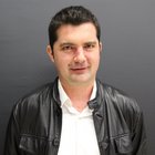 Baumeister und Maurer Porträt eines Mannes in weißem Hemd und schwarzer Lederjacke vor grauem Hintergrund