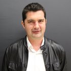 Costruttori e muratori Ritratto di un uomo con camicia bianca e giacca di pelle nera su sfondo grigio