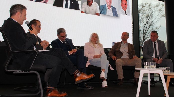 Herausforderungen und Zukunftsperspektiven im alpenquerenden Güterverkehr im Fokus Podiumsdiskussion mit sechs Teilnehmern vor großem Bildschirm mit Porträts