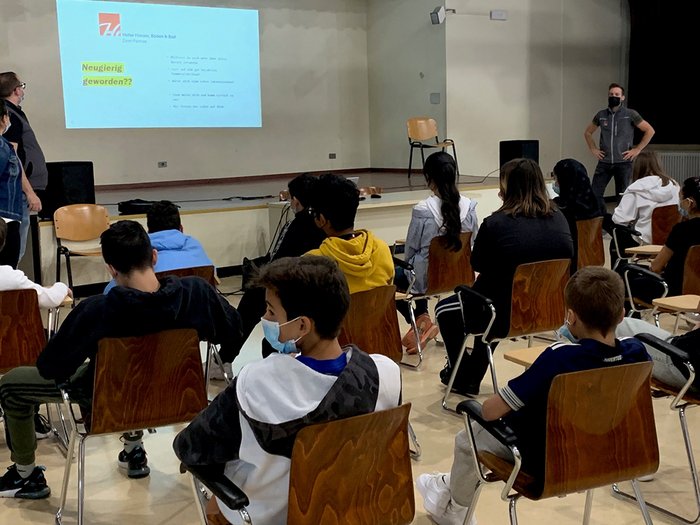 Traumberufe im Handwerk und in der Gastronomie Schüler sitzen mit Masken und schauen eine Präsentation in einem Klassenraum an