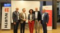 Kfz-Vierländertreffen in Bozen: Wertvoller Austausch und Dialog im Automobilsektor Fünf Personen stehen vor einer Leinwand und Werbebannern bei einer Veranstaltung