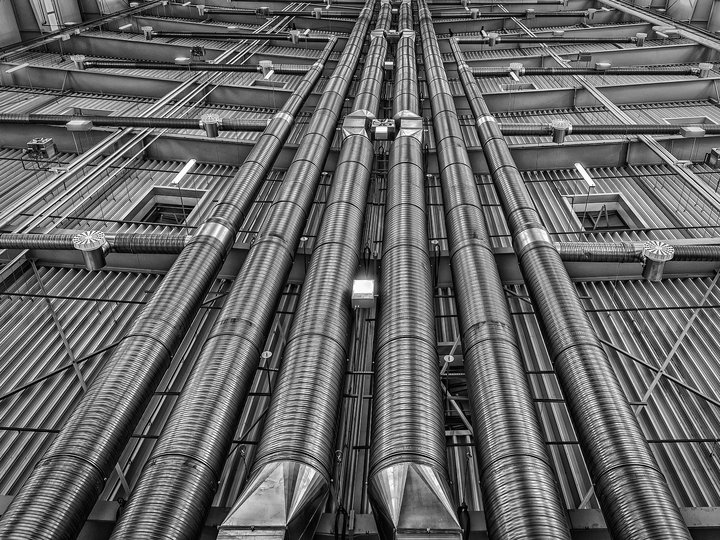 Frigoristi Vista verso l'alto di grandi tubi metallici industriali su una parete del magazzino