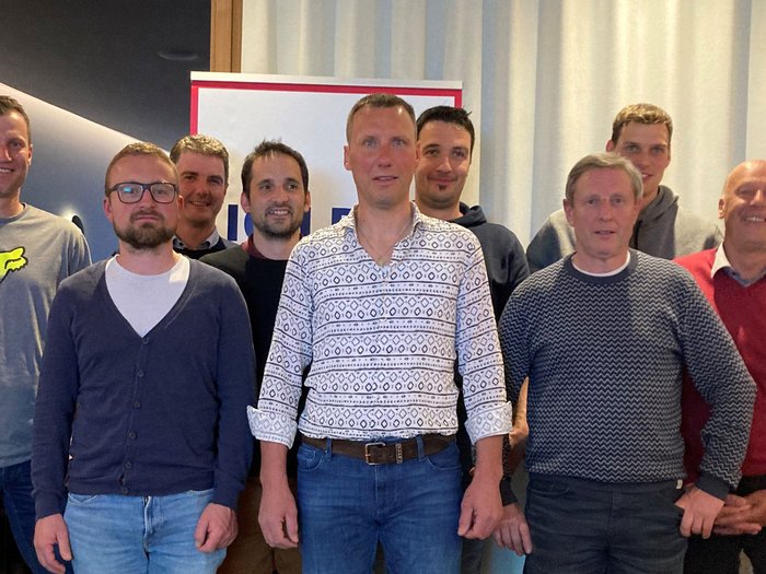 Jenesien: Handwerk gestaltet mit Gruppenfoto von neun Männern vor einem hellen Vorhang