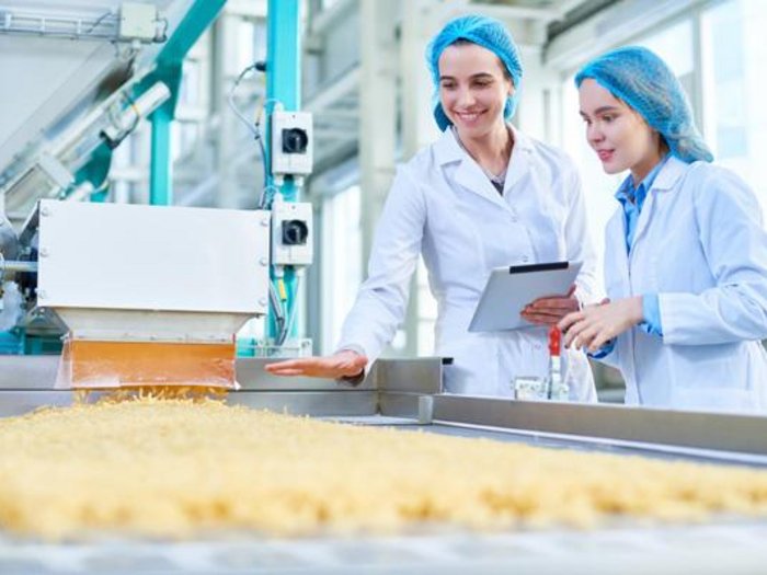 WIFO-Wirtschaftsbarometer Herbst 2023 - Geschäftsklima im Verarbeitenden Gewerbe leicht verschlechtert Zwei Frauen in Laborkitteln überwachen Nudelproduktion in Fabrik