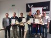 Home Sei uomini che ricevono premi con certificati e regali in un ambiente interno