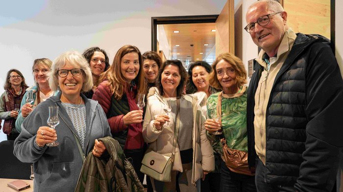 Frauen im Handwerk bei grenzüberschreitendem Netzwerktreffen Gruppe von Erwachsenen, die mit Gläsern anstoßen und lächeln in einem Raum