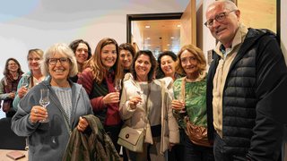 News Gruppe von Erwachsenen, die mit Gläsern anstoßen und lächeln in einem Raum