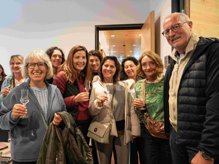 Frauen im Handwerk bei grenzüberschreitendem Netzwerktreffen Gruppe von Erwachsenen, die mit Gläsern anstoßen und lächeln in einem Raum