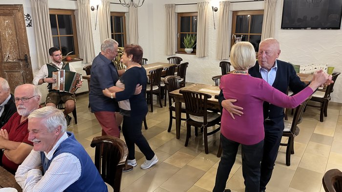Althandwerker/innen unterwegs: Rundfahrt Weinviertel Ältere Paare tanzen im Raum zu Musik von einem Akkordeonspieler