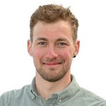 Bozen Land Porträt eines lächelnden jungen Mannes mit kurzem Haar und grünem Hemd