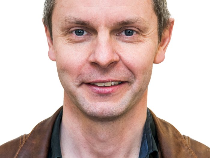 Appalti pubblici e sostenibilità Primo piano di uomo sorridente con giacca di pelle marrone e camicia nera