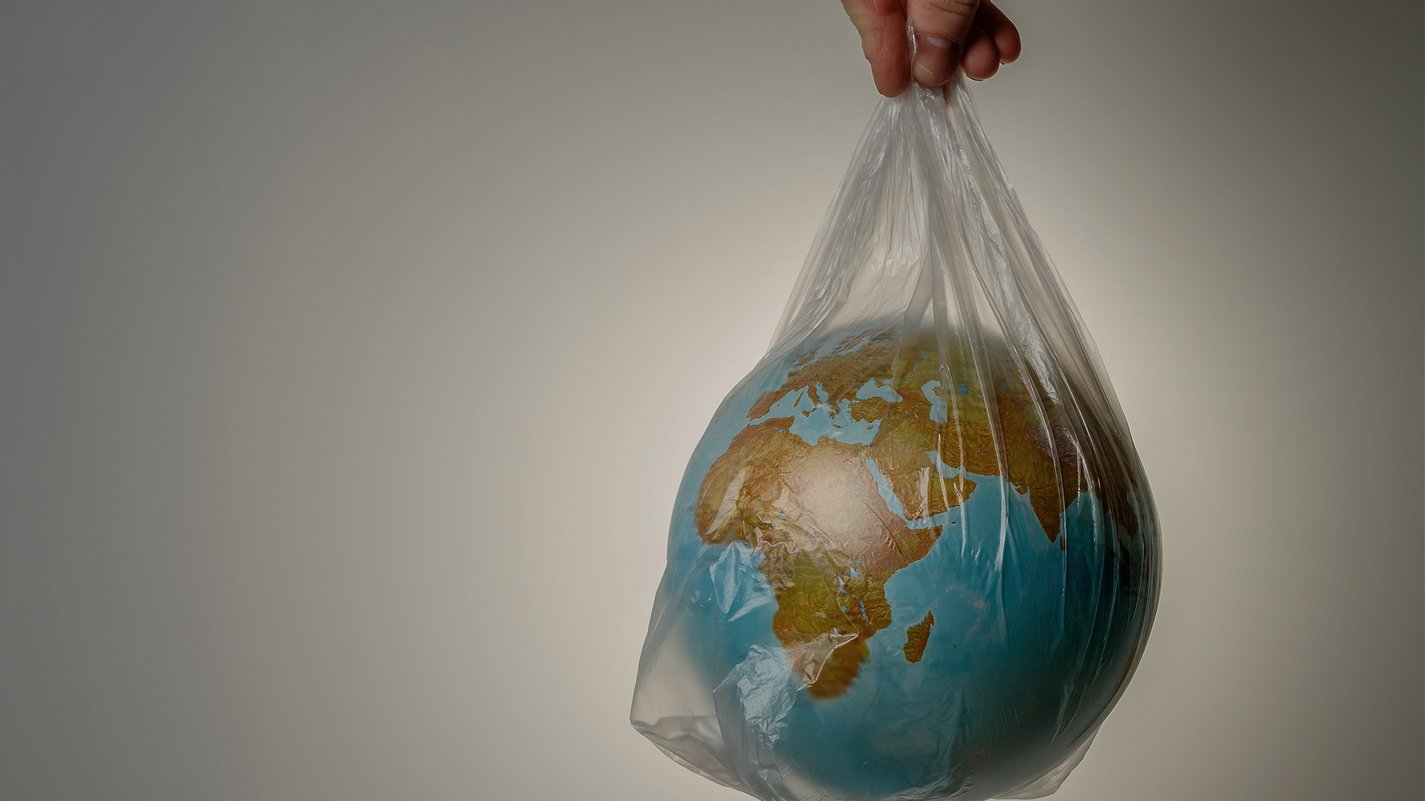 Home Mappamondo in una busta di plastica tenuta in mano, simbolo di ambiente