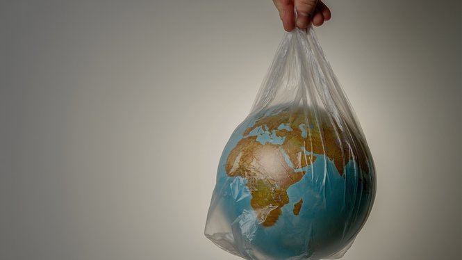 Home Mappamondo in una busta di plastica tenuta in mano, simbolo di ambiente