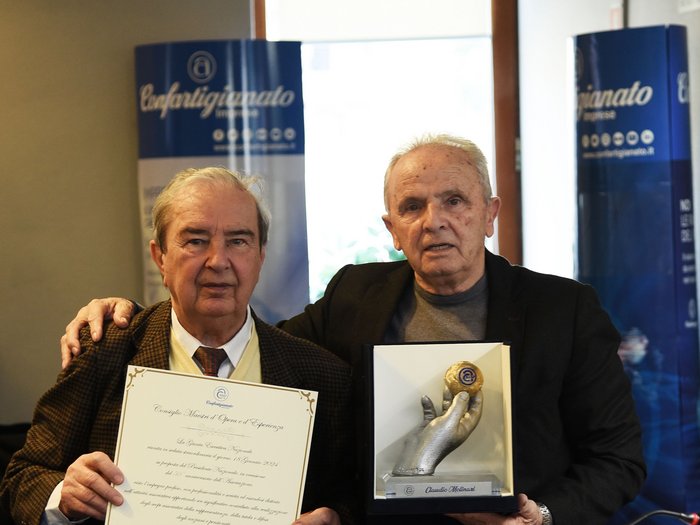 Claudio Molinari zum Ratsmitglied der ANAP ernannt Zwei ältere Männer zeigen eine Urkunde und eine Auszeichnung in einem Büro