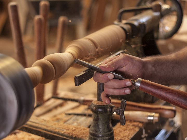 Percorso formazione Mano artigiana che modella il legno su un tornio in movimento