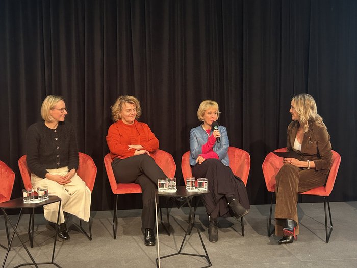 Ricevimento 2025 delle donne nell‘artigianato: “INSIEME creiamo il futuro” Quattro donne sedute su poltrone, una parla con un microfono in mano