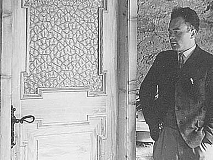 Möbeltischlerei Karnutsch Mann im Anzug steht neben einer Holztür mit verziertem Glas