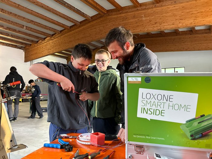 Handwerk hautnah erleben: Die Sarner Mittelschüler/innen entdecken ihre berufliche Zukunft Jugendliche und ein Erwachsener arbeiten an einem Smart Home Projekt in Werkstatt