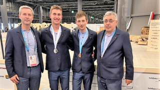 News Quattro uomini in abiti con medaglie a un evento in un capannone