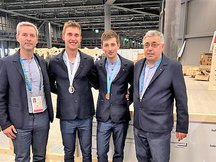 WorldSkills 2022 Special Edition: doppio argento per il Team Italy! Quattro uomini in abiti con medaglie a un evento in un capannone