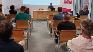 News Menschen bei Vortrag über Berufsschule in einem Seminarraum