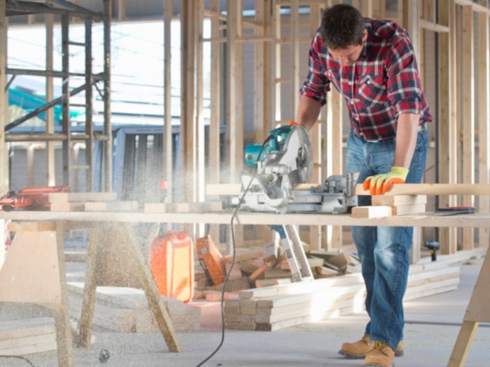 Der Südtiroler Zimmerer-Meistertitel wird jetzt in Deutschland anerkannt Mann sägt Holz mit Kappsäge in Baustelle mit offenem Holzrahmen