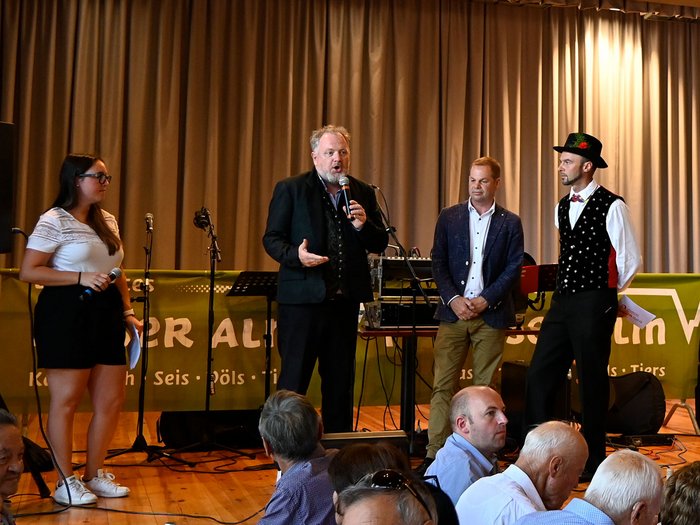 Gli Artigiani Anziani si sono incontrati a Siusi allo Sciliar Quattro persone parlano sul palco davanti a un pubblico durante un evento