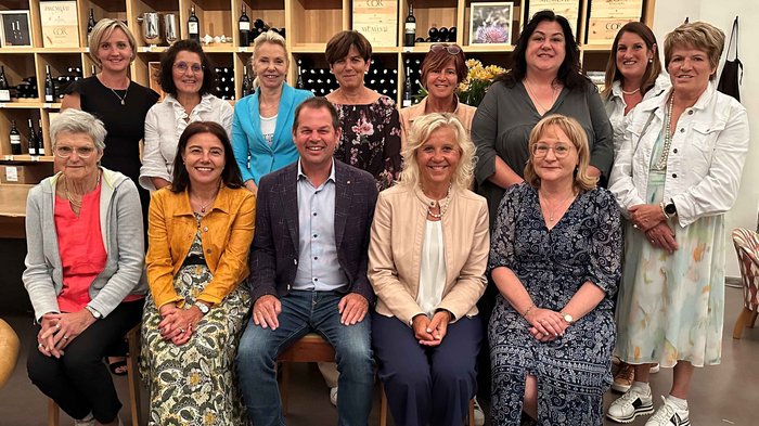 Vorstellung der Garfidi bei den Frauen im Handwerk Gruppenfoto von 14 Personen vor Weinregalen in einem Innenraum