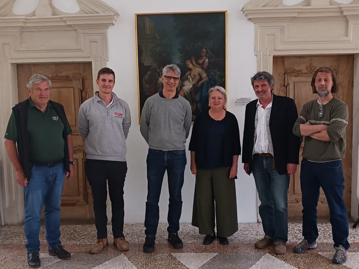 Insieme per il patrimonio culturale: collaborazione sempre più stretta fra artigianato e beni culturali Sei persone in piedi sorridenti davanti a un muro con un dipinto