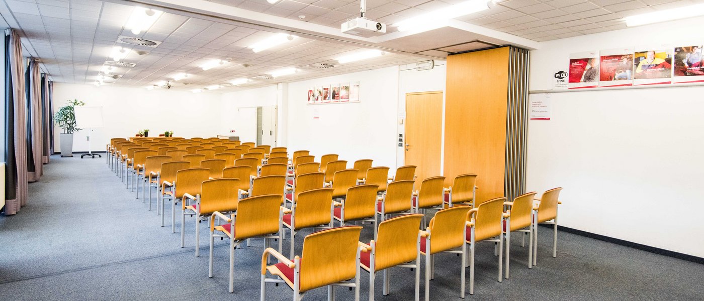 Affitto aule seminari Sala conferenze luminosa vuota con file di sedie in legno