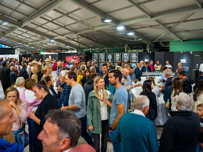 La 31^ Fiera d’Arte UNIKA apre le porte a Ortisei Molte persone a una mostra d'arte in un grande spazio coperto e illuminato