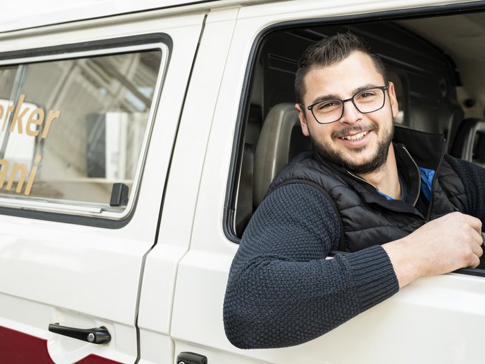Alexander Dallio ist neuer Landesobmann der Junghandwerker Lächelnder Handwerker sitzt im Transporter und schaut aus dem Fenster