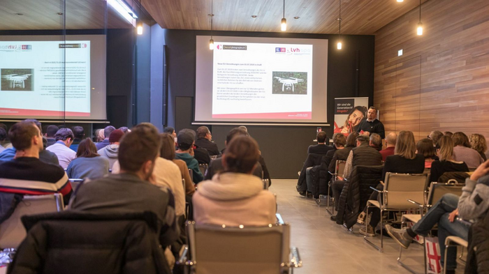 Nutzungsrecht, Urheberrecht & Co Publikum folgt Präsentation zu Drohnenregelungen in modernem Seminarraum