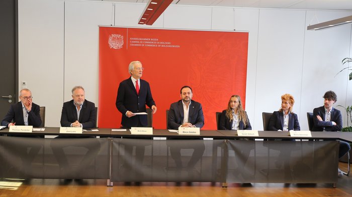 WorldSkills 2024 in Lyon: Südtirol schickt zwölf Teilnehmende Personen bei einer Pressekonferenz vor rotem Banner der Handelskammer Bozen