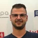 Unterland Porträt eines jungen Mannes mit Brille vor Werbewand