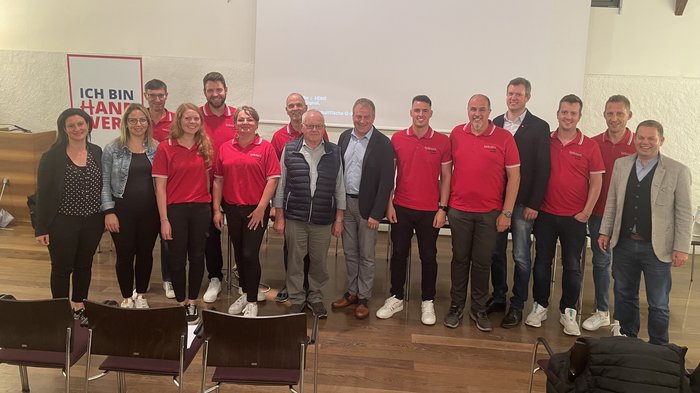 Erfolgreiche lvh-Ortsversammlung in Eppan: Wichtige Zukunftsthemen im Fokus Gruppenfoto von 15 Personen bei einer Veranstaltung mit roter Kleidung und Business Casual