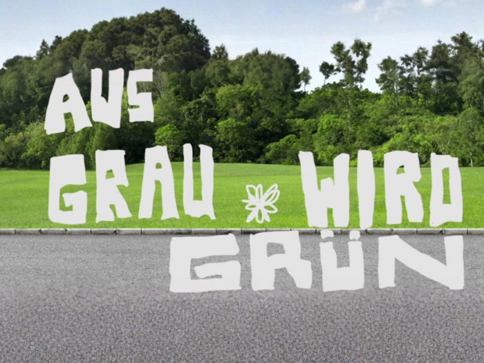Aus Grau wird Grün: Wettbewerb für Entsiegelung und Bodenaufwertung 2026 gestartet Grüne Wiese mit Bäumen im Hintergrund und deutscher Schriftzug