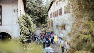 News Menschen bei einer Gartenparty zwischen alten Gebäuden im Freien