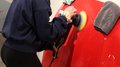 Una settimana intorno all‘artigianato Donna lucida una carrozzeria rossa con una macchina lucidatrice