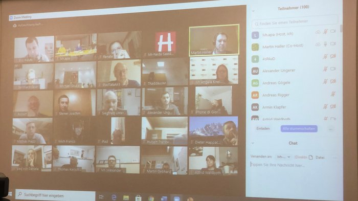 Handwerk: Großteil der Arbeit kann weitergehen Zoom-Meeting mit mehreren Teilnehmern auf einem Bildschirm projiziert