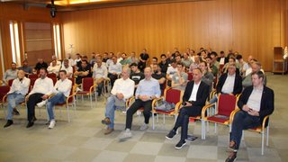 News Gruppo di uomini seduti in una sala conferenze che ascoltano attentamente