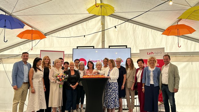 40 Jahre Frauen im Handwerk Gruppe von Menschen bei Feier unter Regenschirmen in einem Zelt