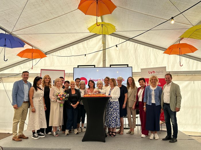 40 Jahre Frauen im Handwerk Gruppe von Menschen bei Feier unter Regenschirmen in einem Zelt