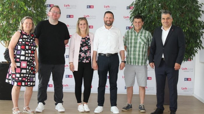 Kurs für zukünftige Mietwagenunternehmer/innen Sechs Personen in einem Raum vor LVH-apa Banner posieren für Foto