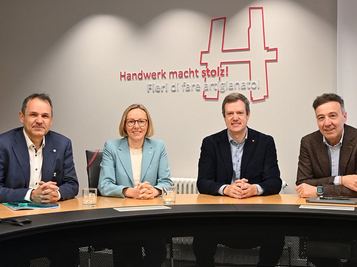 Orientierungspraktika als Schlüssel zur Fachkräftesicherung Vier Personen sitzen an einem Tisch vor einer Wand mit der Aufschrift Handwerk macht stolz