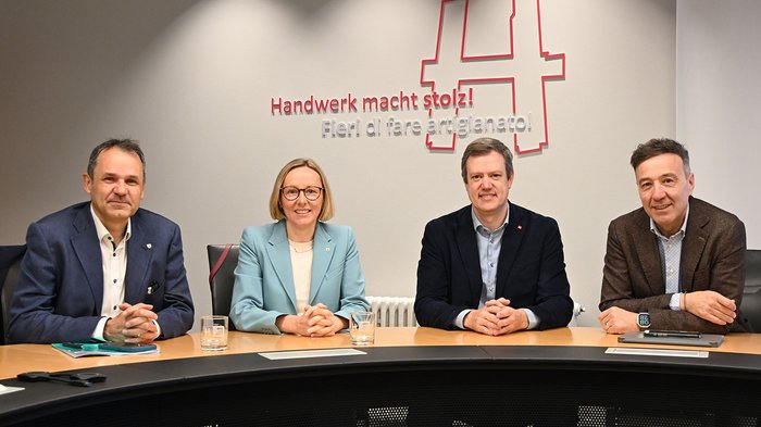 Ziel erreicht: Ausnahmen beim Taschenmesserverbot beschlossen Vier Personen sitzen an einem Tisch vor einer Wand mit der Aufschrift Handwerk macht stolz