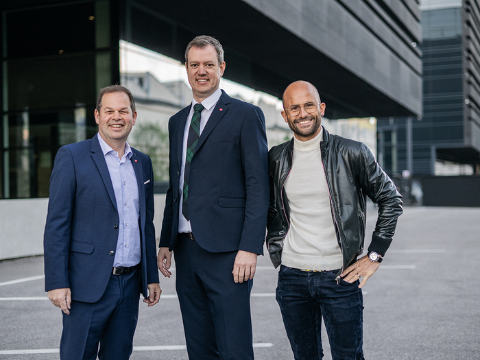 Frohe Weihnachten wünscht das lvh-Präsidium Drei Männer stehen lächelnd vor einem modernen Gebäude