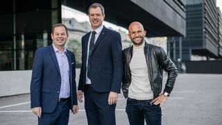 News Tre uomini sorridenti in piedi davanti a un edificio moderno