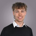 Il team di lvh.apa Giovane uomo con capelli ricci e camicia bianca sotto maglione nero